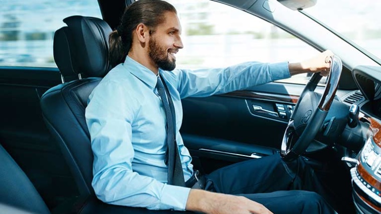 Photographie représentant un chef d'entreprise heureux dans leur nouvelle voiture provenant d’Allemagne